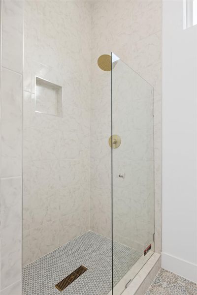 Bathroom featuring a tile shower and tile patterned flooring Bathroom featuring a tile shower and tile patterned flooring