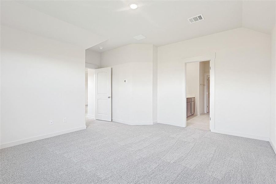 Carpeted spare room with vaulted ceiling