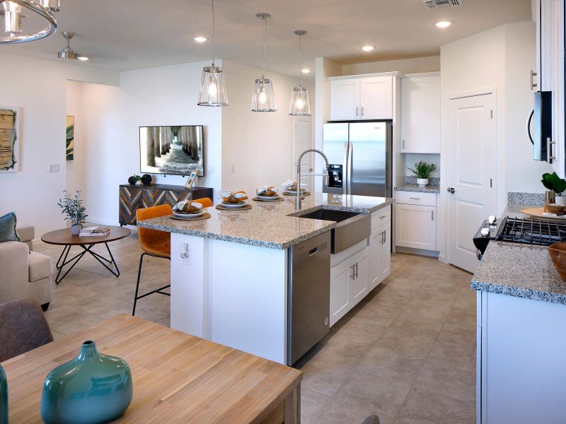 Free flowing kitchen featuring white cabinets and white granite counter tops