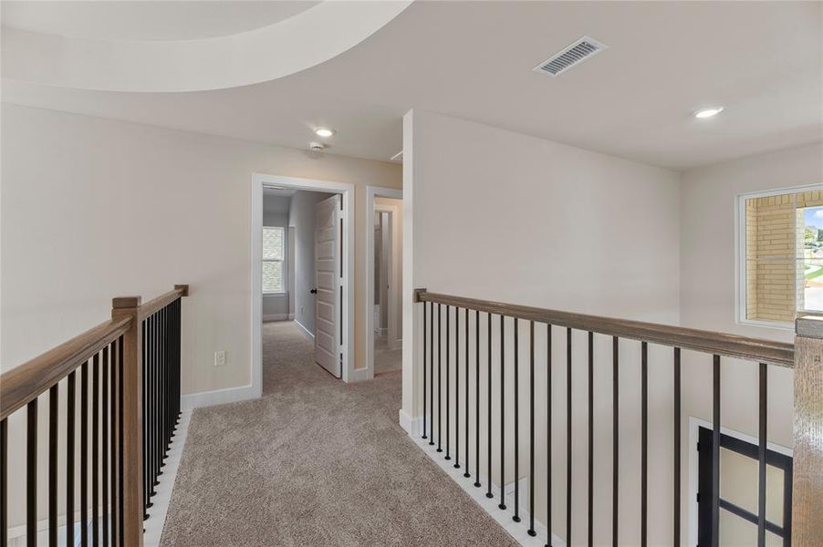 Hallway featuring light carpet, recessed lighting, and an upstairs landing