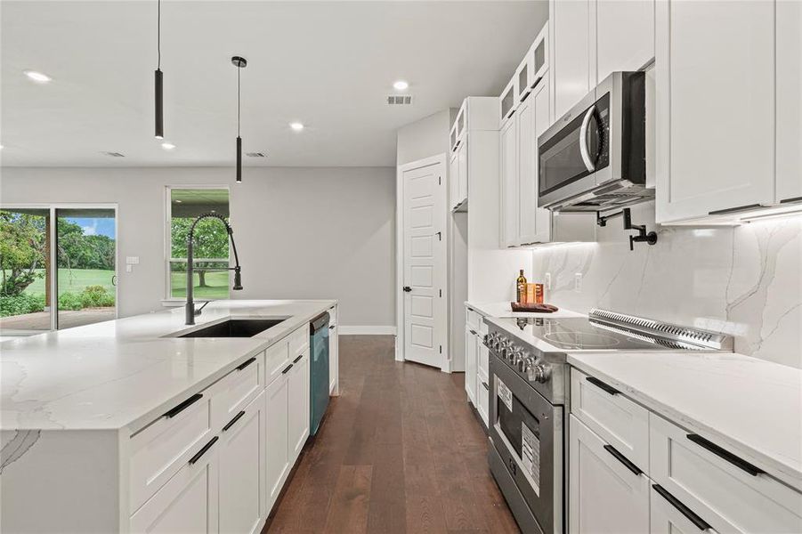 Kitchen featuring electric range, stainless steel microwave, white cabinets, dishwasher, and recessed lighting