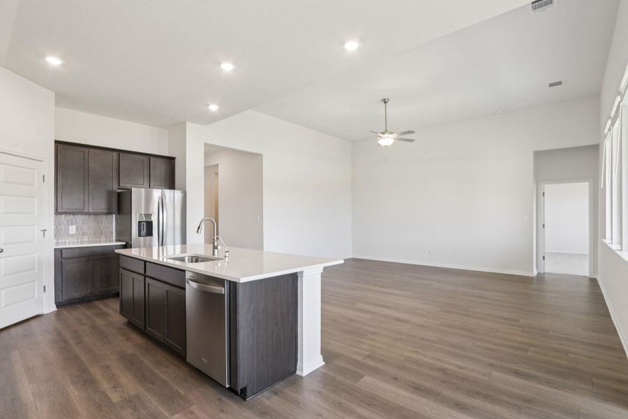 Kitchen with appliances with stainless steel finishes, tasteful backsplash, an island with sink, dark wood-type flooring, and recessed lighting Kitchen with appliances with stainless steel finishes, tasteful backsplash, an island with sink, dark wood-type flooring, and recessed lighting