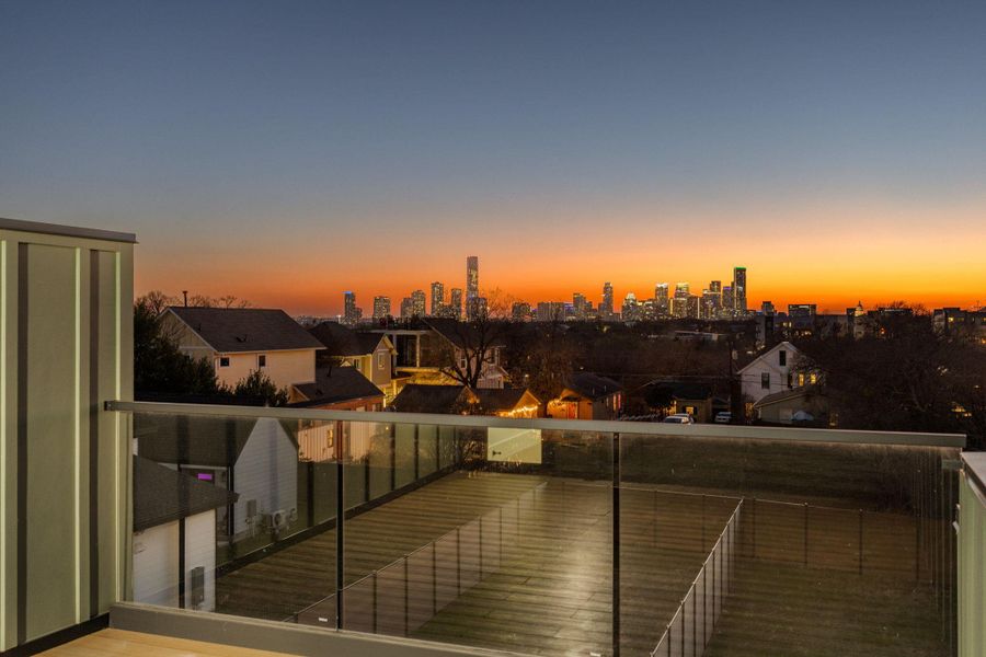 Balcony at dusk featuring a skyline view