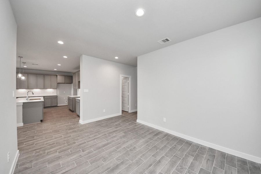 Make memories gathered around the table with your family and friends! This spacious dining room features elegant flooring, custom paint, and adjacent to family room and kitchen for open concept feel. Sample photo of completed home with similar floor plan. Actual colors and selections may vary.