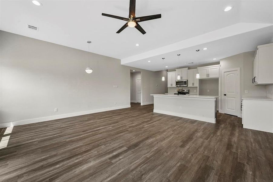 Unfurnished living room with dark wood-type flooring and ceiling fan