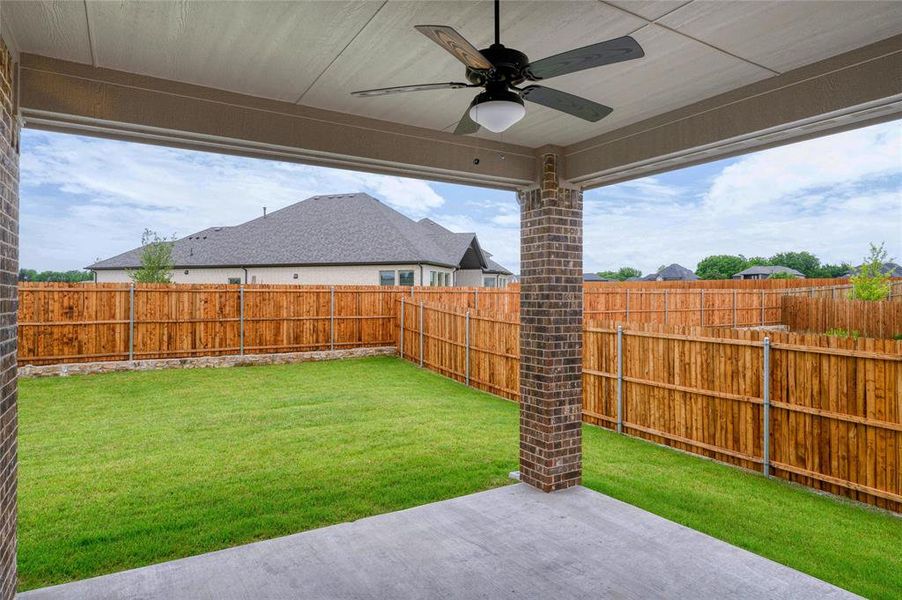 Fenced backyard featuring a ceiling fan and a patio area Fenced backyard featuring a ceiling fan and a patio area