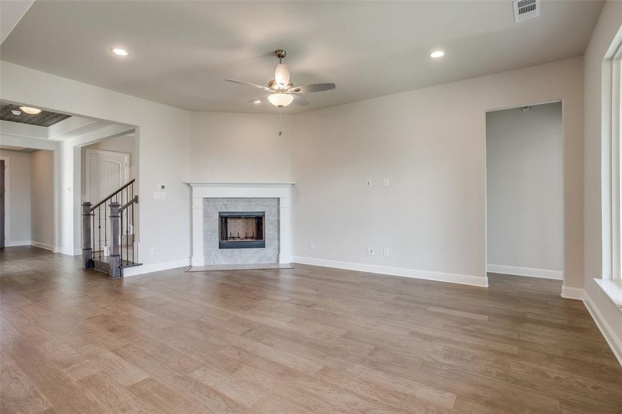 Unfurnished living room featuring light hardwood / wood-style floors, a fireplace, and ceiling fan