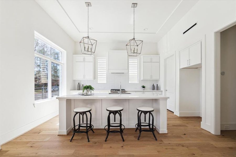 Fully Appointed – Well equipped kitchen comes with painted shaker style cabinets, endless quartz countertops, ceramic backsplash, under counter lighting and eye-catching carriage light pendants hanging over the island, perfect illumination throughout.