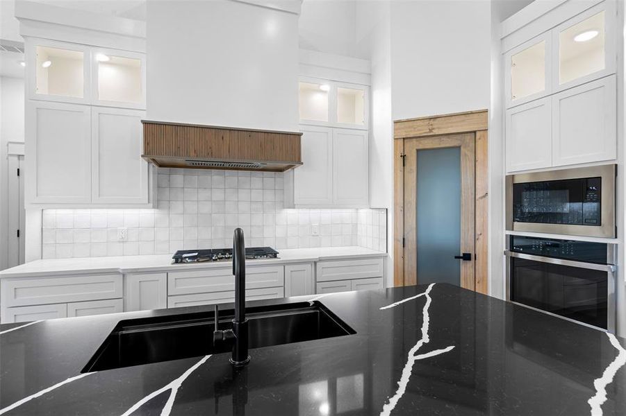 Kitchen with white cabinetry, tasteful backsplash, and appliances with stainless steel finishes