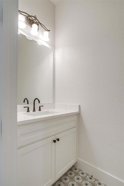 Bathroom featuring vanity, tile patterned floors, and baseboards