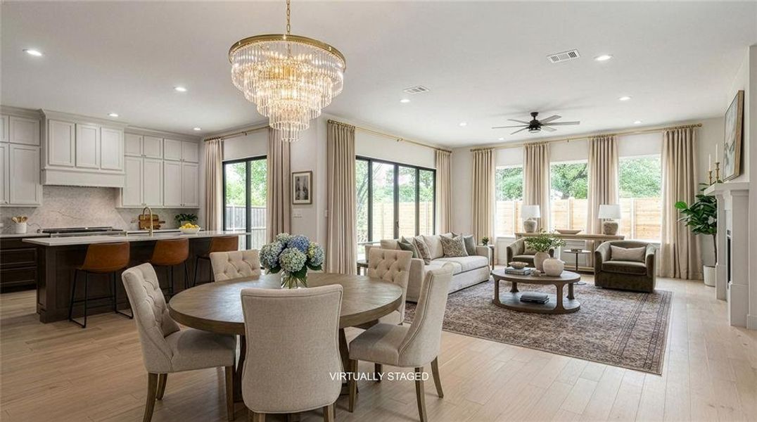 Huge open floorplan with ease of flow from living to kitchen to dining room space. Notice the white oak wide planked engineered wood and decorative chandelier. Huge open floorplan with ease of flow from living to kitchen to dining room space. Notice the white oak wide planked engineered wood and decorative chandelier.
