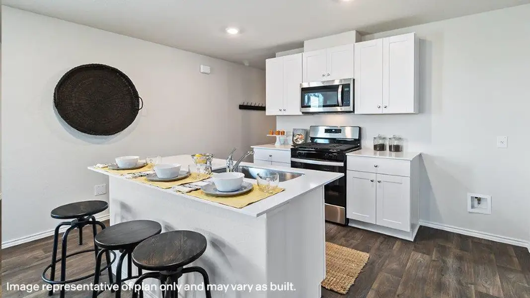 Sleek stainless steel appliances enhance this kitchen's practical island with a breakfast bar. Sleek stainless steel appliances enhance this kitchen's practical island with a breakfast bar.