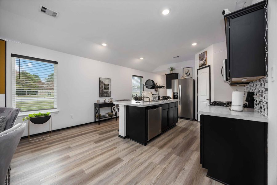 it has ample natural light from large windows and a central island for versatile use. Perfect for cooking and entertaining.