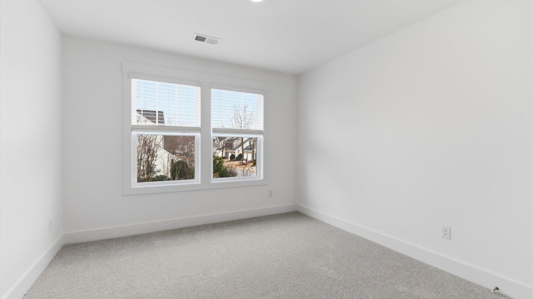 First-rate bedroom with plush carpeting and large windows that provide an open, airy feel