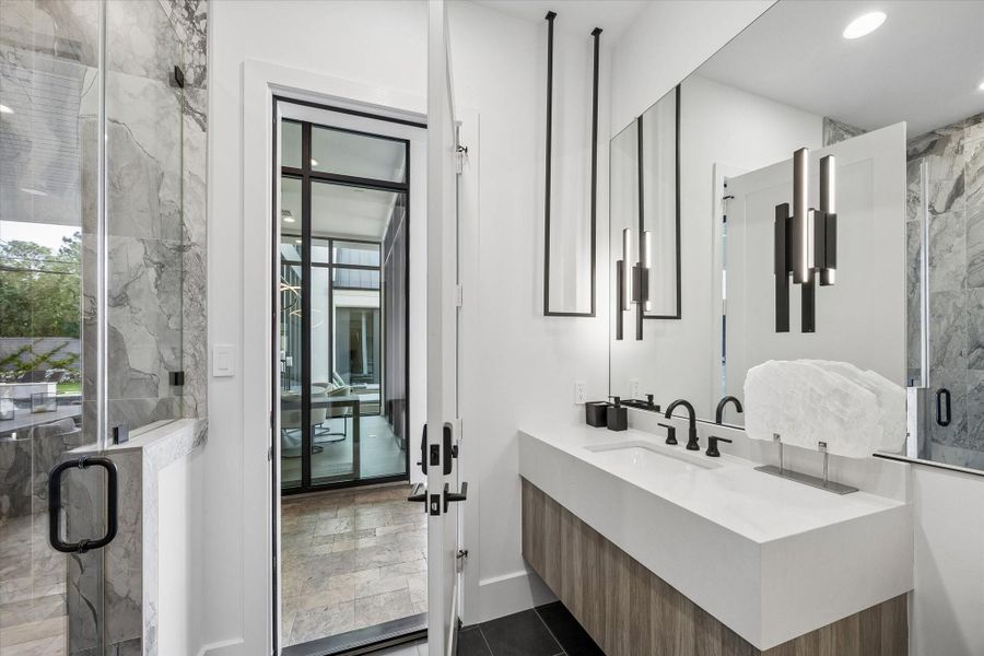 The downstairs pool bathroom with a full shower and hanging towel rack. The downstairs pool bathroom with a full shower and hanging towel rack.
