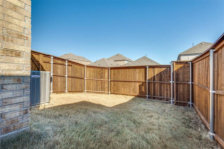 View of yard featuring central air condition unit & privacy fence