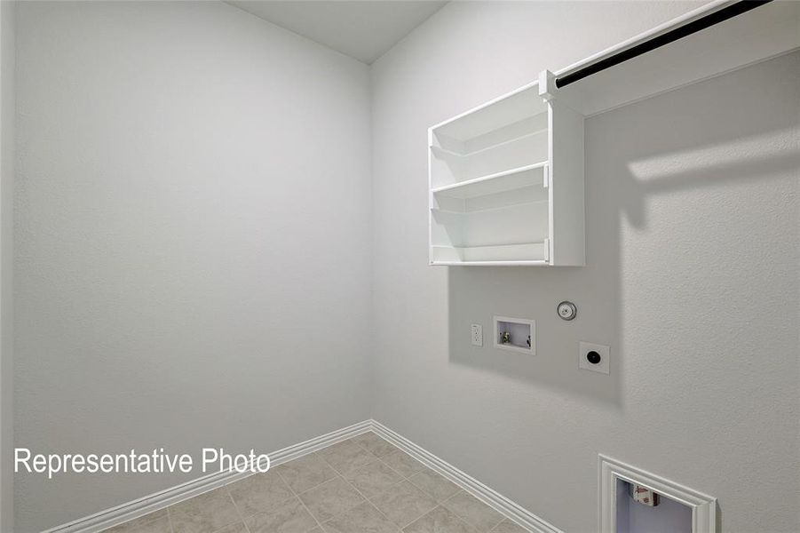 Laundry room featuring gas dryer hookup, light tile patterned floors, hookup for a washing machine, and hookup for an electric dryer