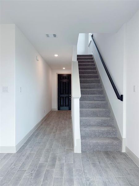 Staircase with recessed lighting, visible vents, wood finish floors, and baseboards