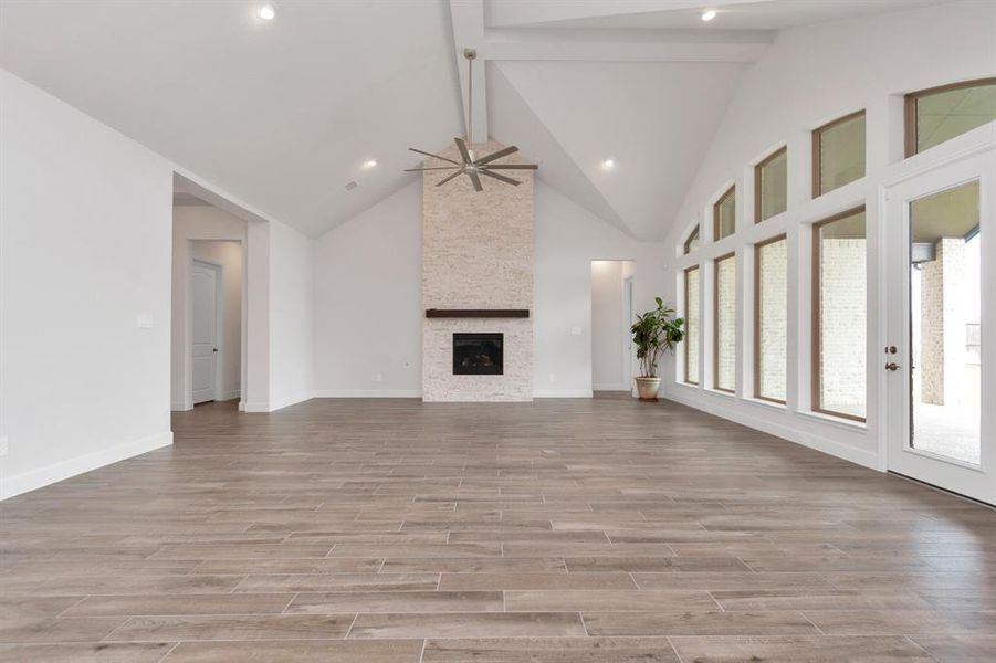 This gorgeous fireplace with floor to ceiling stone accent and a wood mantle serves as a focal point in this open-concept living space!