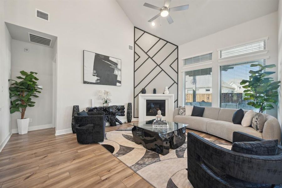 Living room featuring ceiling fan, high vaulted ceiling, and wood-type flooring