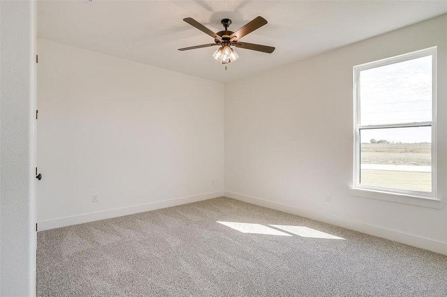 Carpeted empty room with ceiling fan