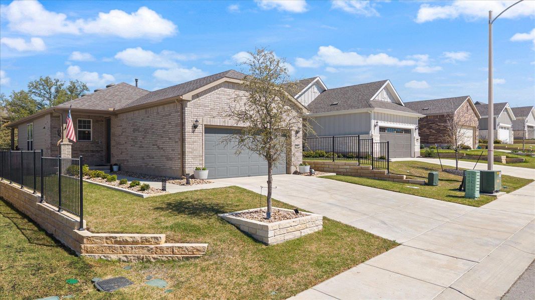 View of front of property with brick siding, a garage, driveway, and a residential view View of front of property with brick siding, a garage, driveway, and a residential view