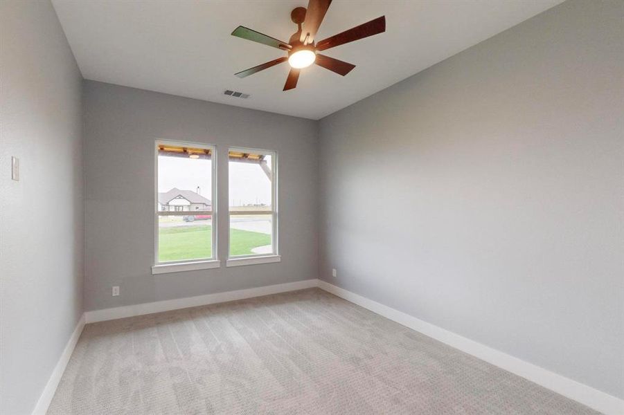 Carpeted spare room featuring ceiling fan