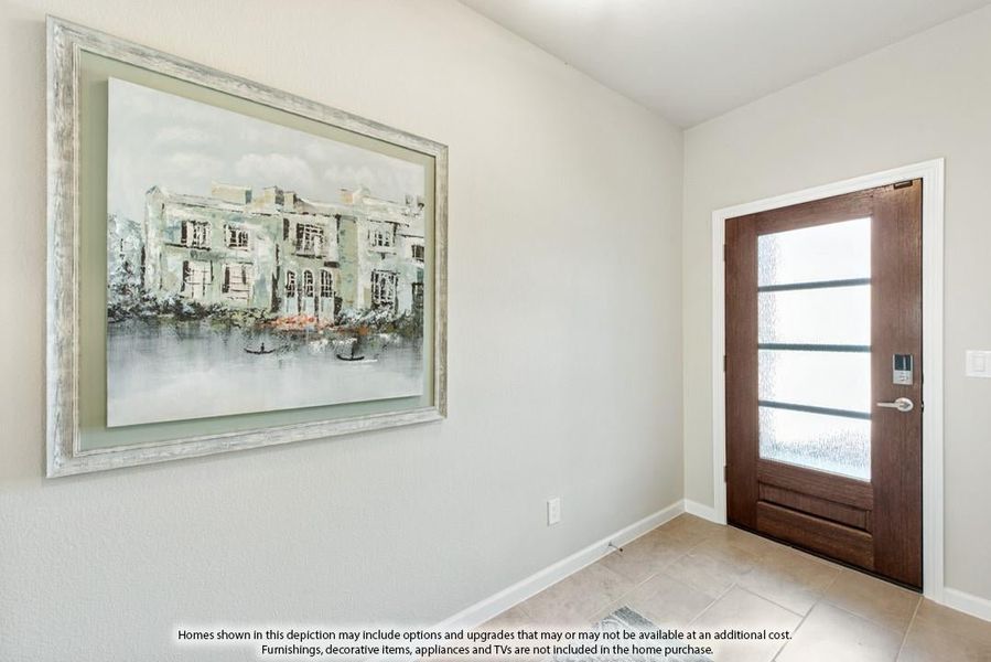 Home entryway with wood front door with glass panels and large framed wall art on tile floor
