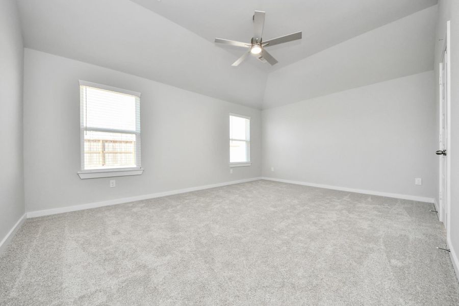 Escape to tranquility in this spacious primary room, adorned with plush carpeting and bathed in the soothing hues of warm paint colors, creating a cozy retreat for relaxation. Sample photo of completed home with similar floor plan. Actual colors and selections may vary.
