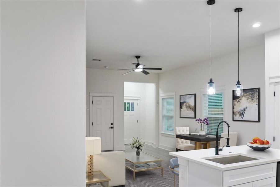 Kitchen with white cabinetry, light countertops, pendant lighting, a ceiling fan, and plenty of natural light Kitchen with white cabinetry, light countertops, pendant lighting, a ceiling fan, and plenty of natural light