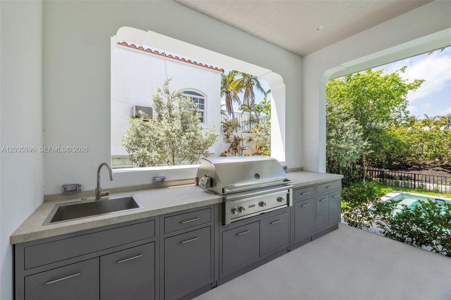 Outside living room with kitchen overlooks pool Outside living room with kitchen overlooks pool