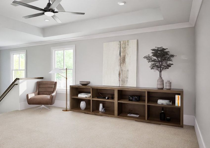 Open loft space with neutral carpet, ceiling fan, brown accent chair, wooden bookcase, and decorative accents near the staircase.