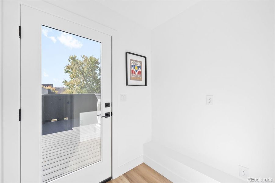 A sunlit flex space plumbed for a wet bar offers easy access to the rooftop deck for effortless entertaining.