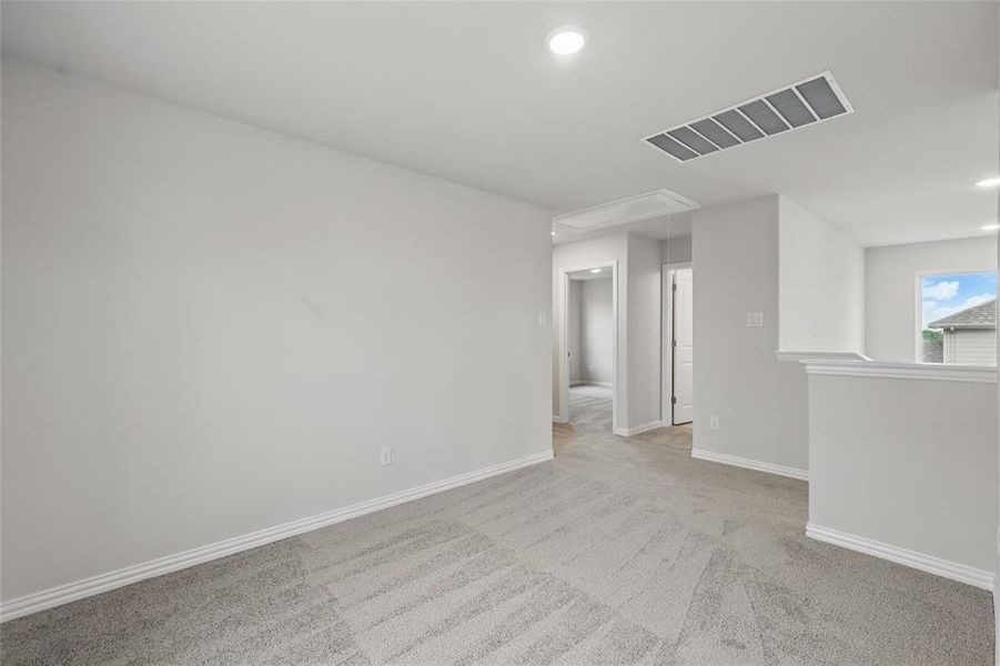 Unfurnished room with attic access, light colored carpet, and recessed lighting