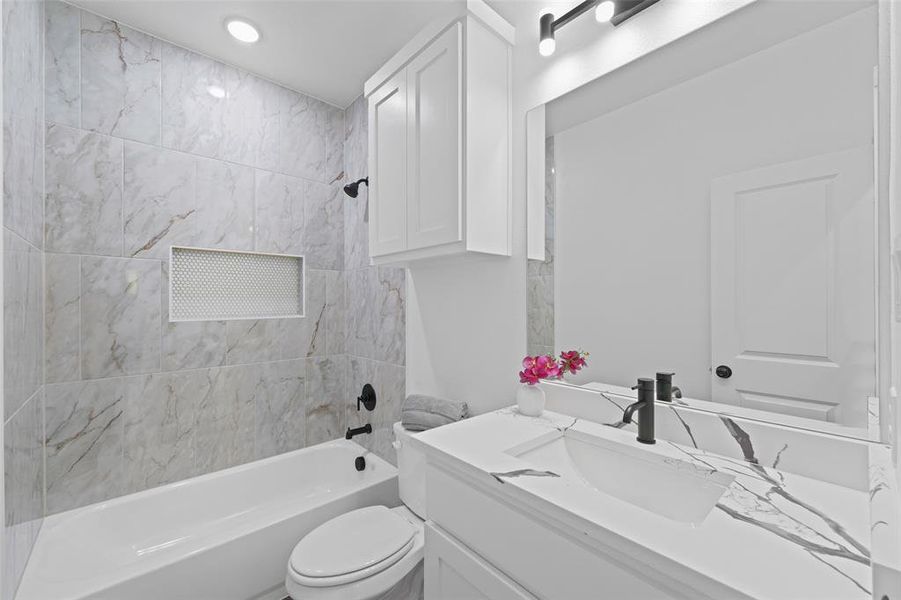Bathroom featuring a white vanity with an integrated rectangular sink, a black single-handle faucet, and a large mirror Bathroom featuring a white vanity with an integrated rectangular sink, a black single-handle faucet, and a large mirror