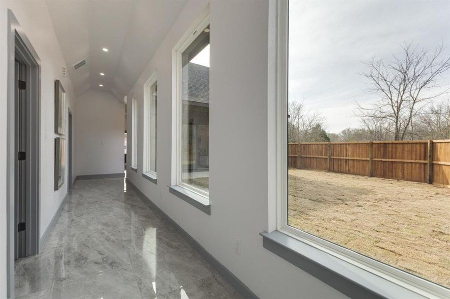 Corridor with lofted ceiling and plenty of natural light