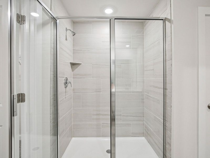 The primary bathroom offers dual vanity sinks and a walk-in shower.