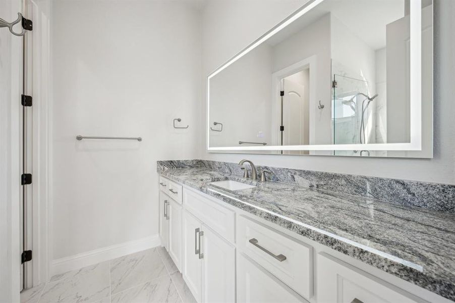 Private ensuite guest bathroom with large vanity, shower enclave, and toilet room.