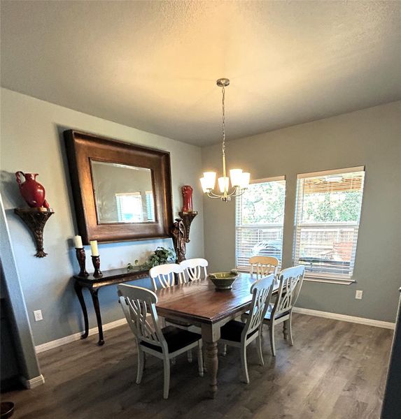 A refined dining space features elegant wood flooring, large windows, and a classic chandelier, ideal for entertaining. A refined dining space features elegant wood flooring, large windows, and a classic chandelier, ideal for entertaining.