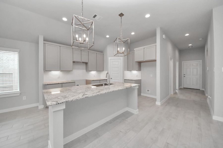 This kitchen is truly a chef's dream! This haven Boasts high ceilings, recessed & pendant lighting, stained wood cabinets, granite countertops, stainless steel appliances, a modern tile backsplash.  All of this overlooks your expansive family room, creating a perfect space for culinary delights and family gatherings.