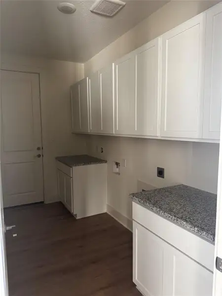 Laundry area featuring washer hookup, dark wood-type flooring, cabinet space, electric dryer hookup, and a textured ceiling Laundry area featuring washer hookup, dark wood-type flooring, cabinet space, electric dryer hookup, and a textured ceiling