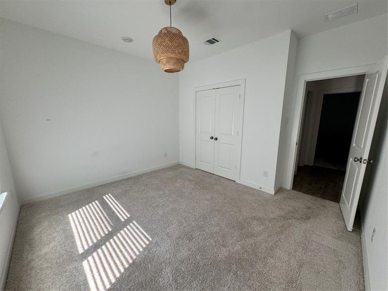 Bedroom featuring light carpet and a closet Bedroom featuring light carpet and a closet
