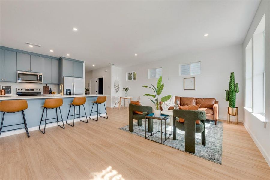 Living room featuring sink and light hardwood / wood-style flooring