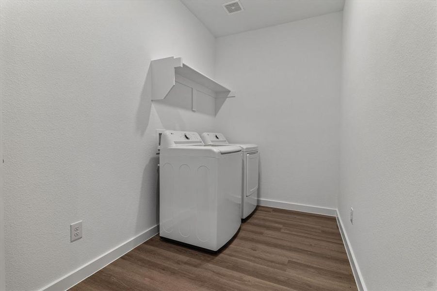 Laundry area featuring separate washer and dryer and dark wood-type flooring