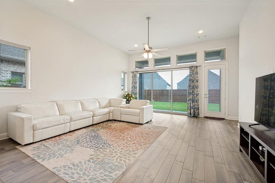 Living area with high ceilings, recessed lighting, and wood-finish flooring