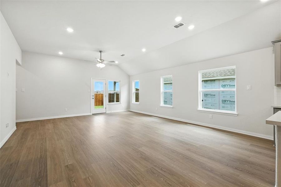 Unfurnished living room with vaulted ceiling, light wood finished floors, recessed lighting, and ceiling fan