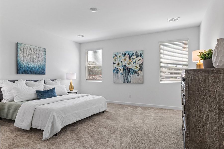 A bedroom with a bed and a lamp.