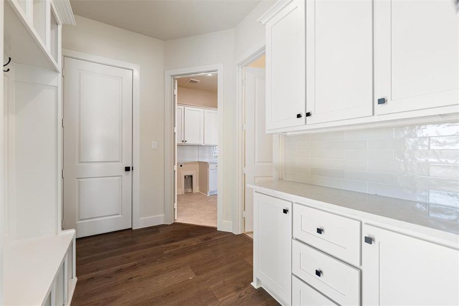 Hall featuring dark wood-style flooring and baseboards