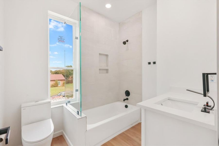 Full bathroom with light wood-style flooring, vanity, shower / bathtub combination, and recessed lighting Full bathroom with light wood-style flooring, vanity, shower / bathtub combination, and recessed lighting