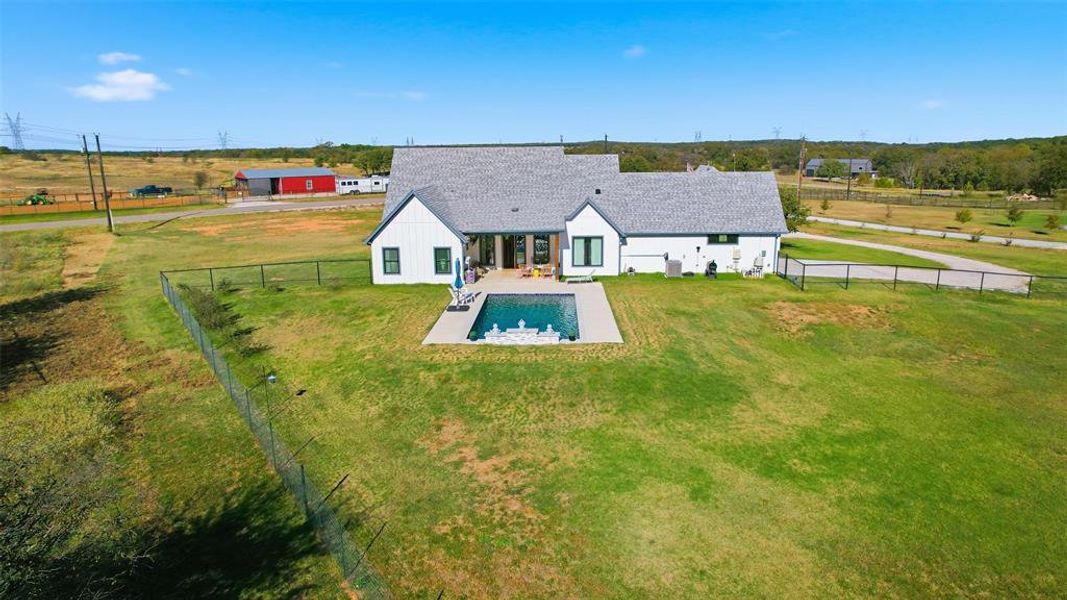 Rear view of house with a patio area, a fenced backyard, and a view of countryside Rear view of house with a patio area, a fenced backyard, and a view of countryside